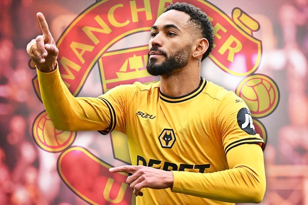 Soccer player in a yellow jersey with the Manchester United logo in the background.