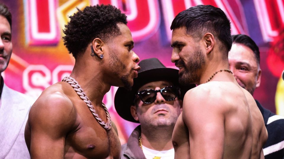 Two boxers facing each other at a weigh-in.