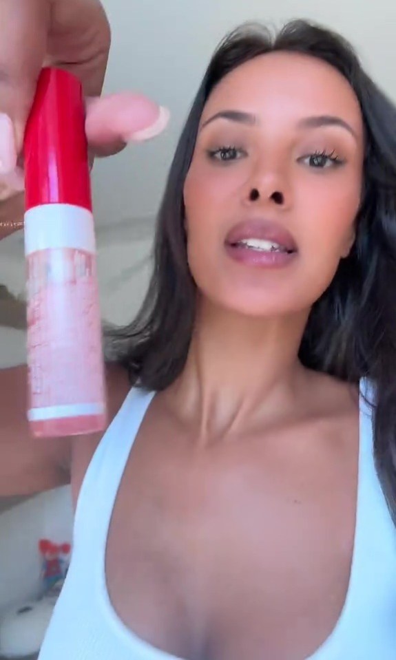 Woman holding a tube of lip gloss.
