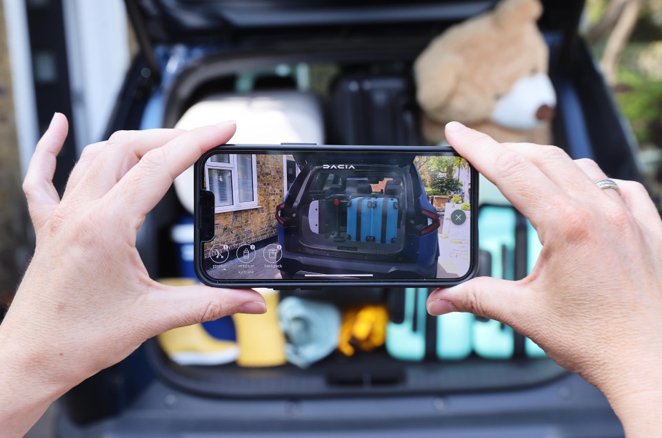 Person using a phone app to measure the space in a car trunk.