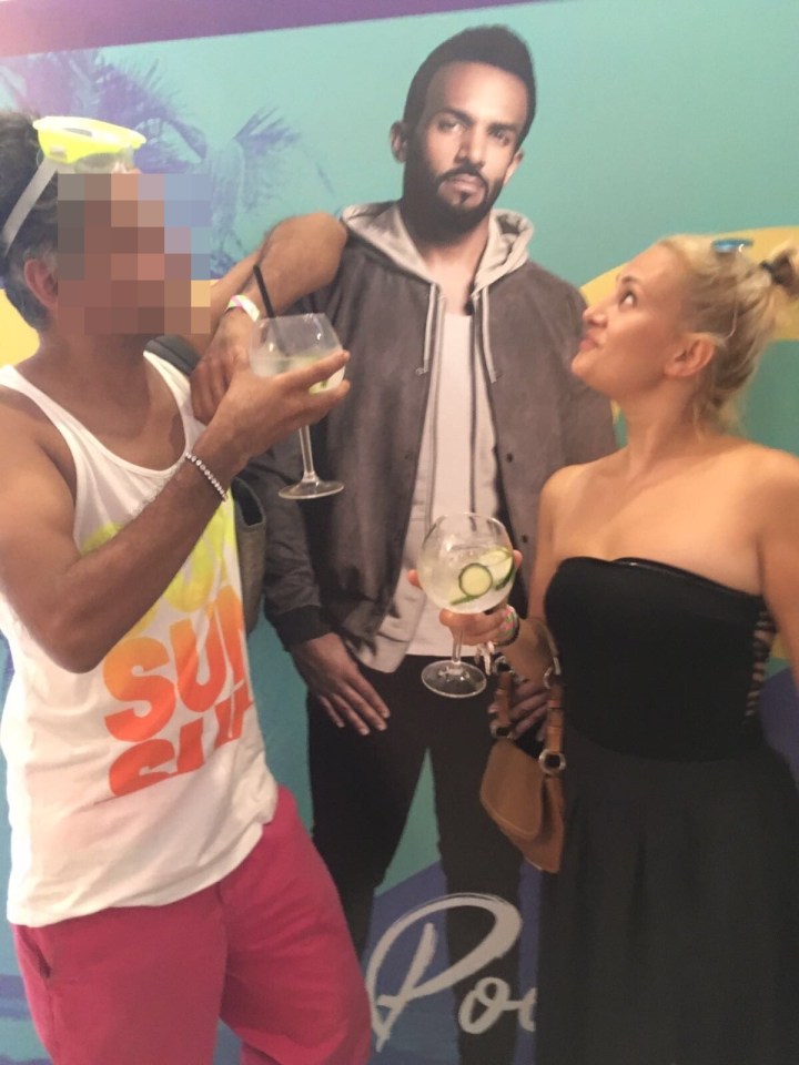 Two people with drinks posing with a Craig David cutout at Ibiza Rocks Hotel.