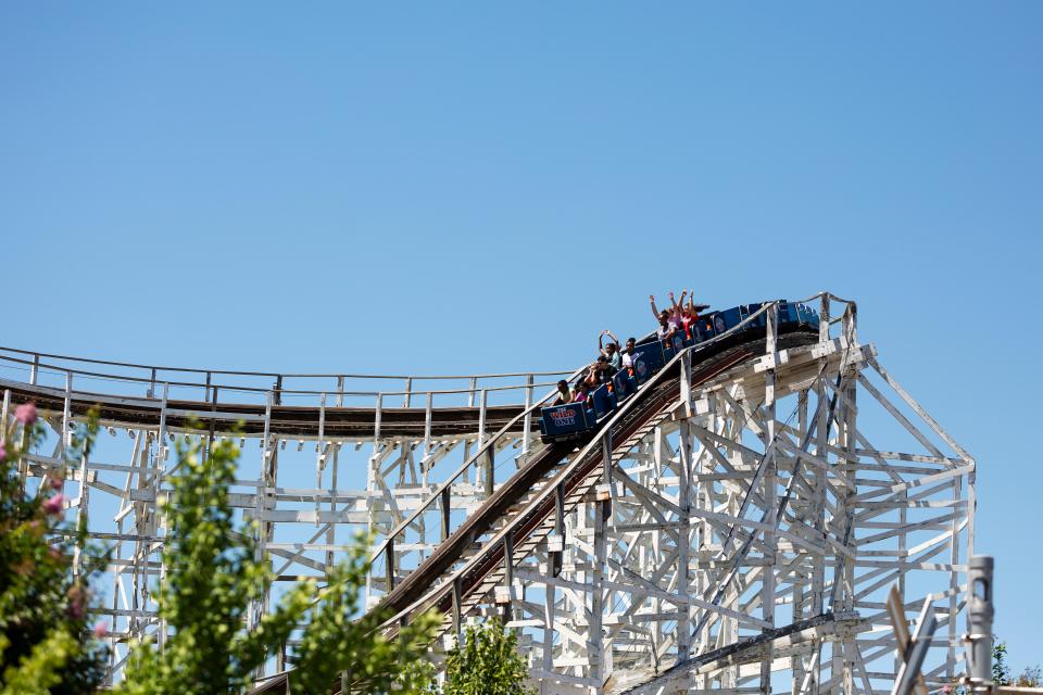 Roller coaster car ascending a wooden roller coaster.