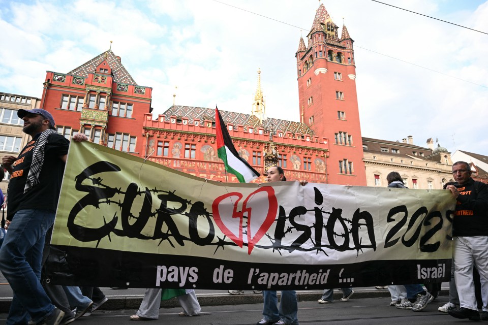 Protestors holding a banner that reads "Eurovision 2023 pays de l'apartheid... Israël" and a Palestinian flag.