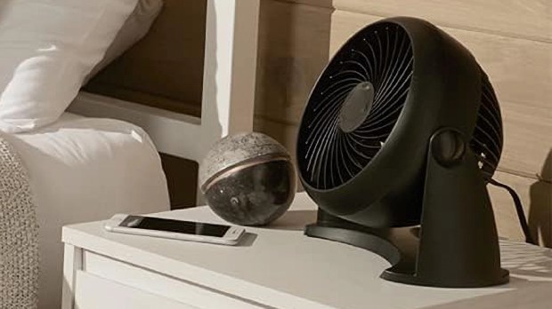 Black Honeywell Turboforce desk fan on a nightstand.