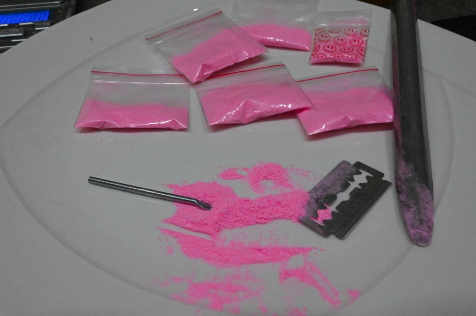 Pink cocaine in baggies on a plate with razor blade and other drug paraphernalia.