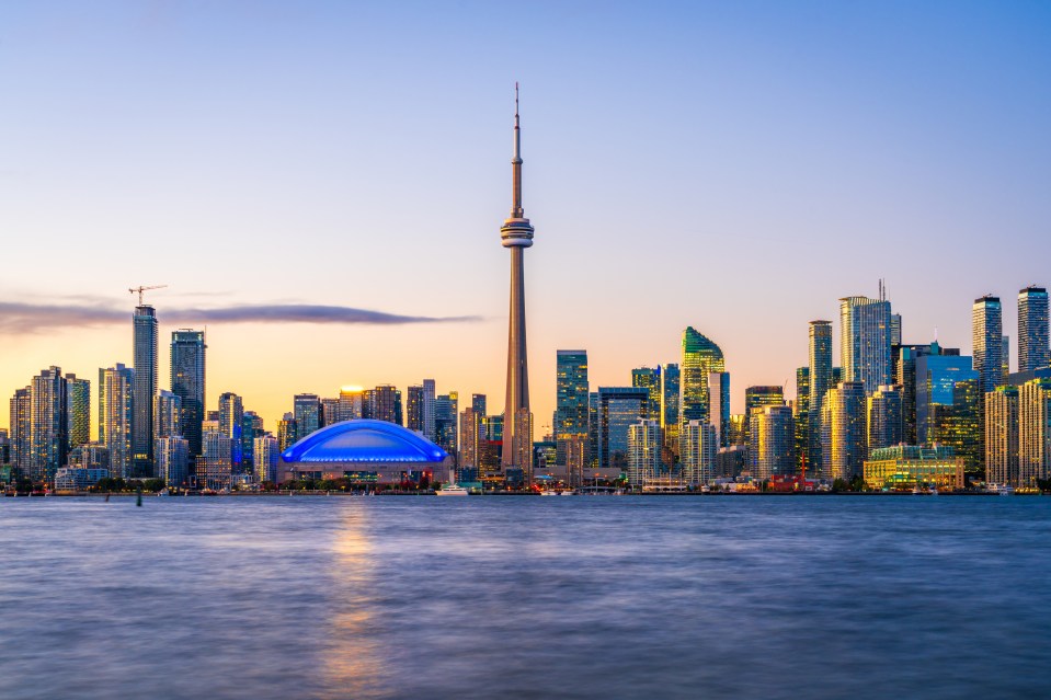 Toronto skyline at dusk over Lake Ontario.
