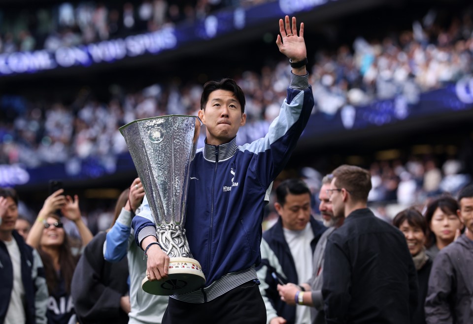 Son Heung-Min of Tottenham Hotspur holding the UEFA Europa League trophy and waving to the crowd.