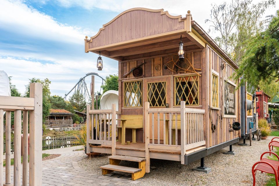 Rustic wooden cabin with a porch, resembling a Western-style building.