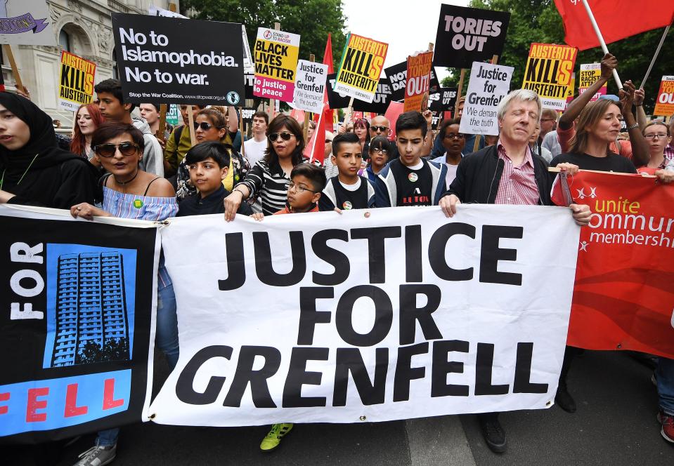 Sadness and shock quickly turned to anger with protesters holding a banner reading 'Justice for Grenfell' during an anti-austerity demonstration outside Parliament in London on July 1