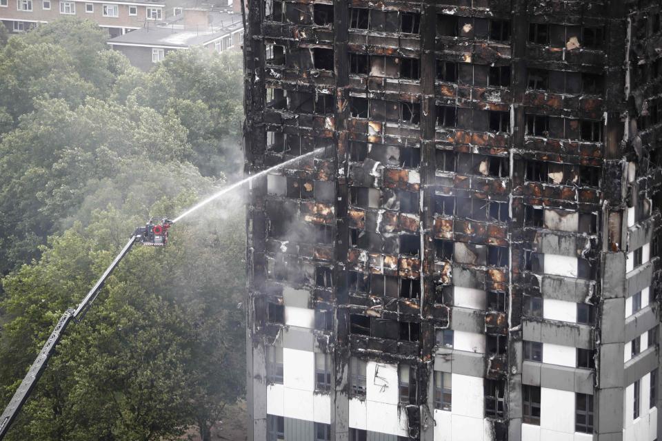 An automated hose sprays water onto Grenfell Tower the following day, with the fire finally getting under control