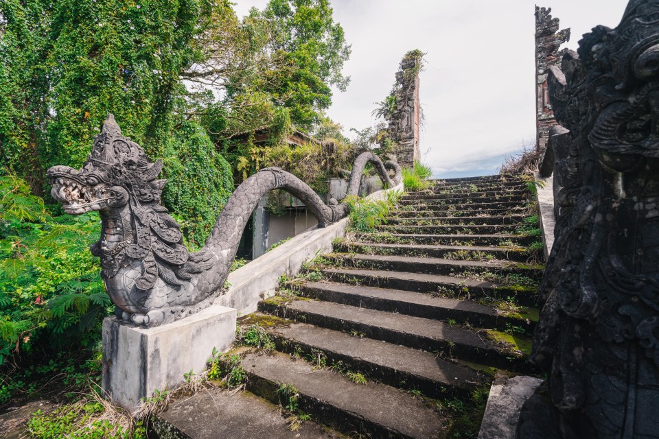 Giant stone serpent statues sit on either side of the powerful staircase