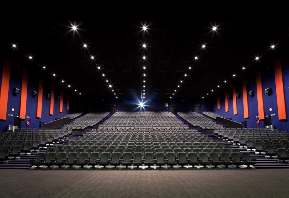 Large movie theater auditorium with many empty seats.