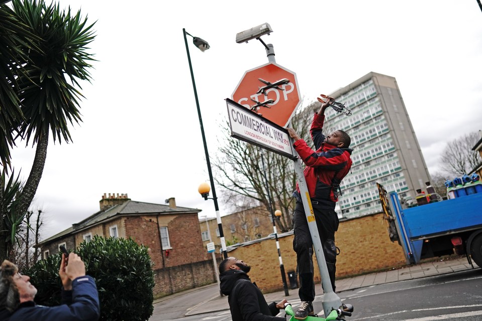People remove a piece of art work by Banksy