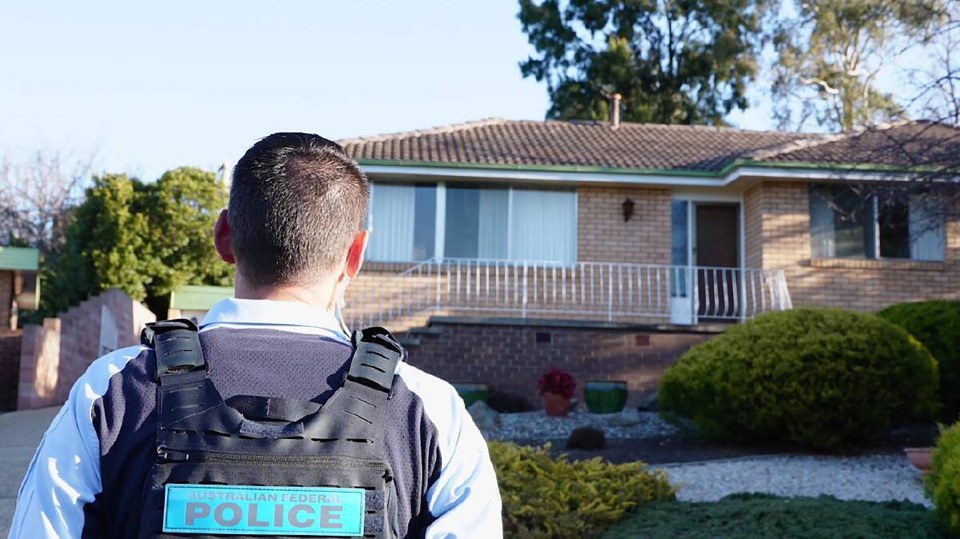 An ACT police officer outside the Fisher house on Monday