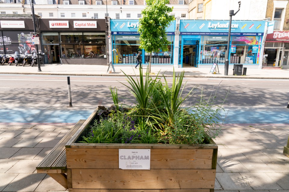 a wooden planter with a sign that says clapham