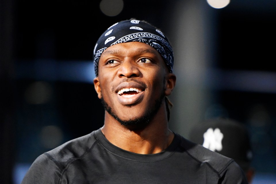 a man wearing a bandana and a ny hat smiles