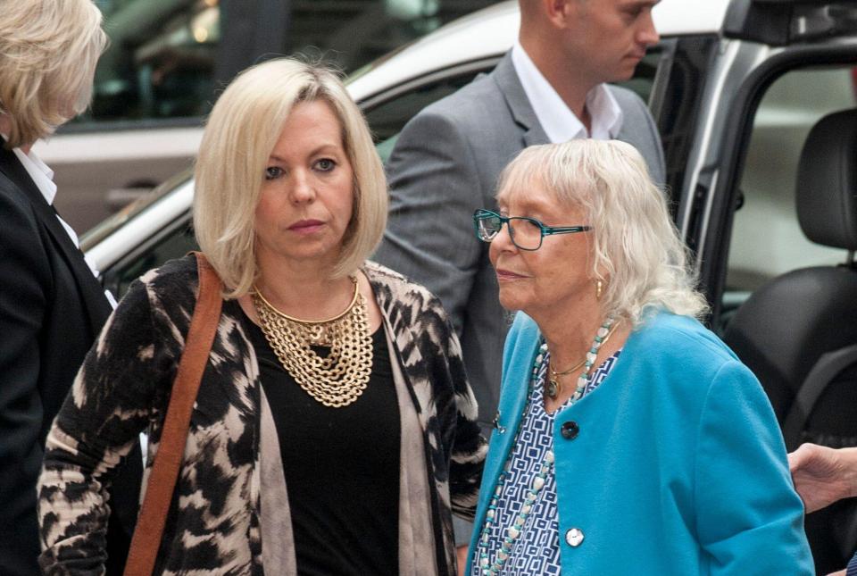 two women standing next to each other with one wearing glasses