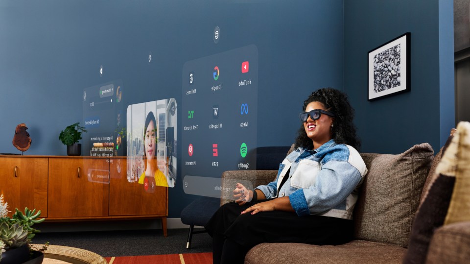 a woman sits on a couch in front of a screen that says spotify