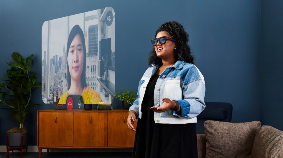 a woman wearing glasses stands in front of a screen that says id