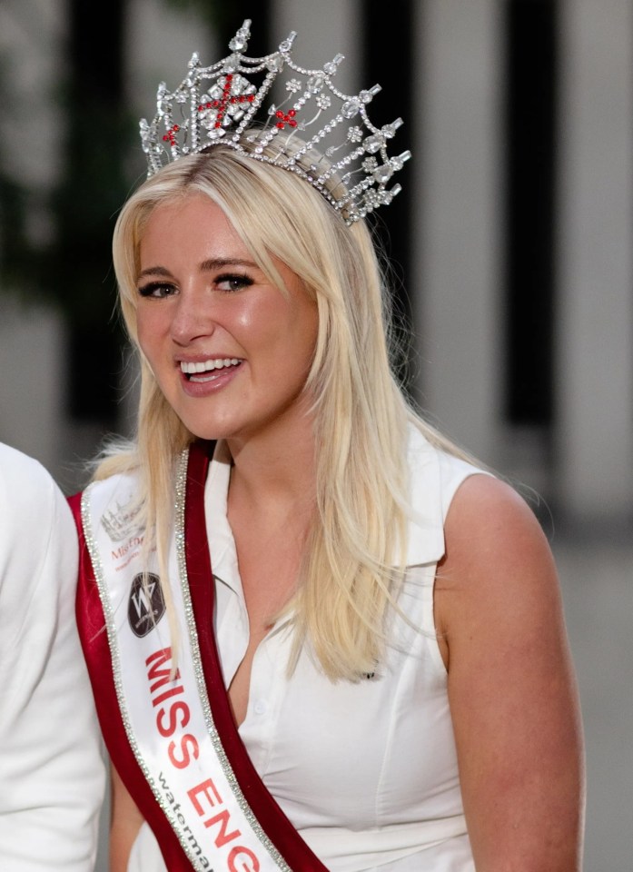 a woman wearing a miss england sash stands next to a man
