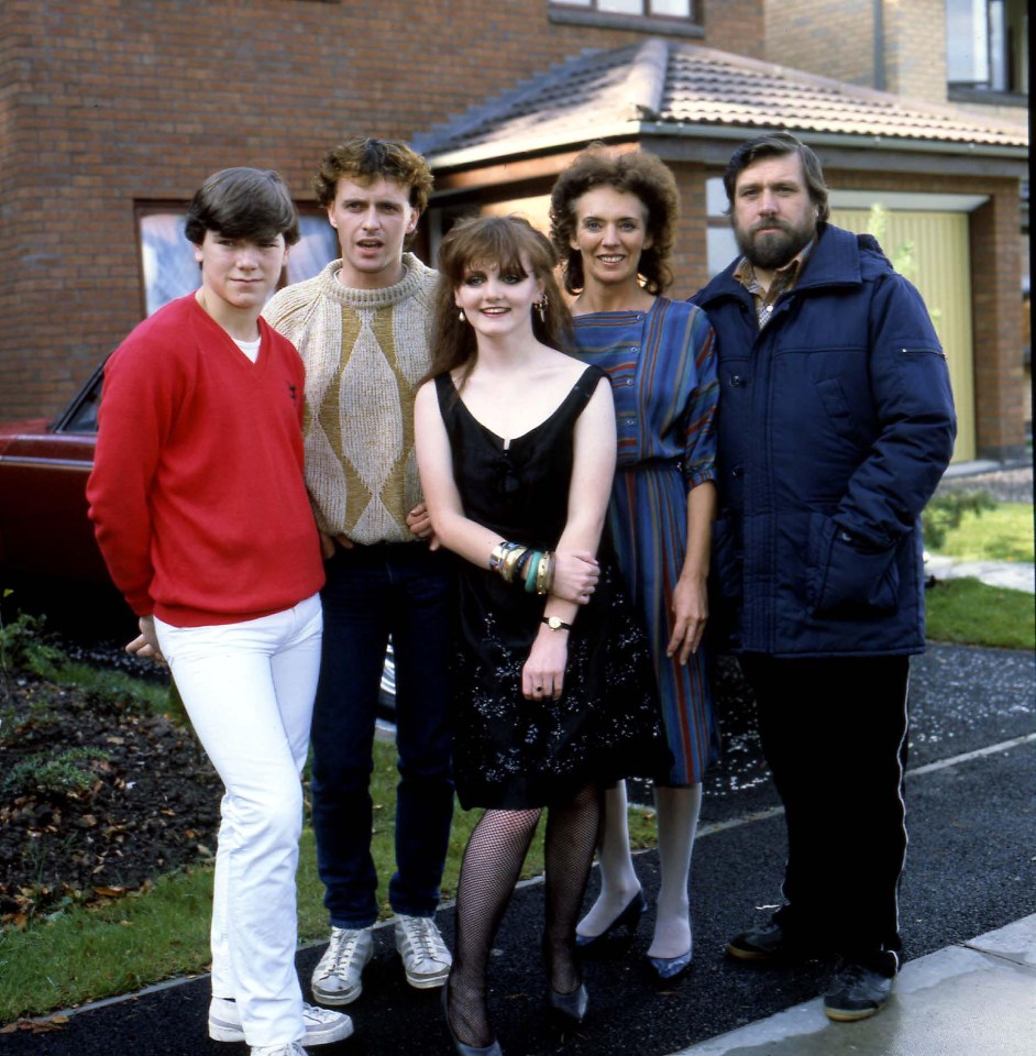 a group of people posing for a picture in front of a house