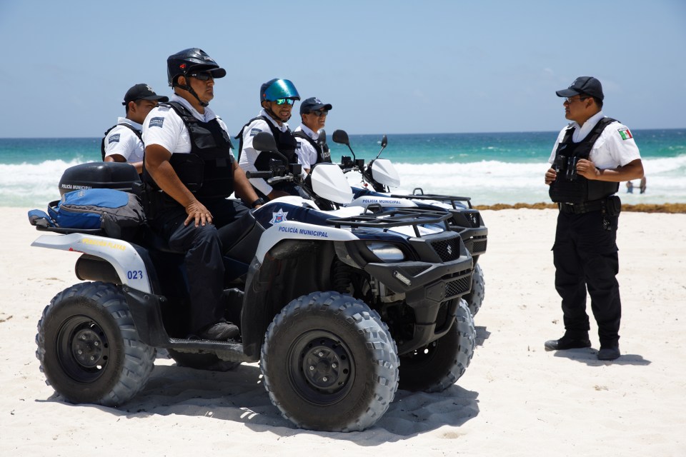 a group of police officers are on the beach