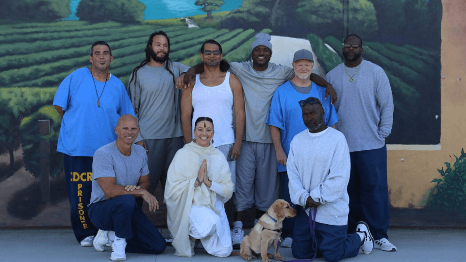 a group of people posing in front of a wall that says dcr prison