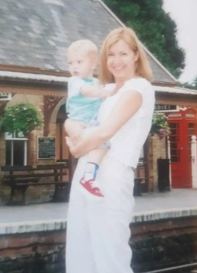 a woman holding a baby in front of a building that says office