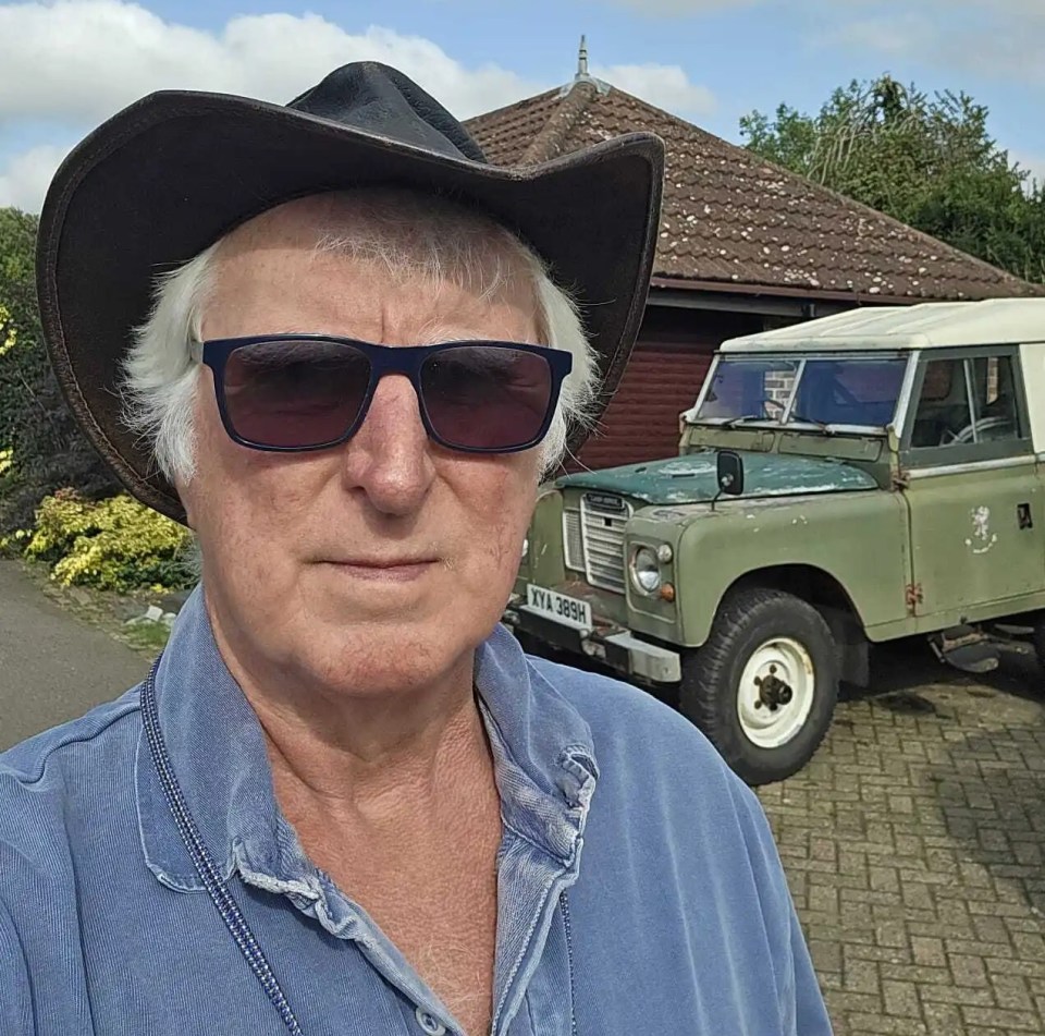 a man wearing a cowboy hat and sunglasses stands in front of a green land rover
