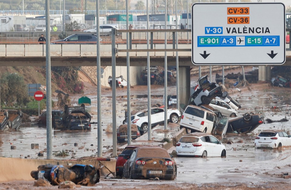 a flooded street with a sign that says cv-33 cv-36 valencia