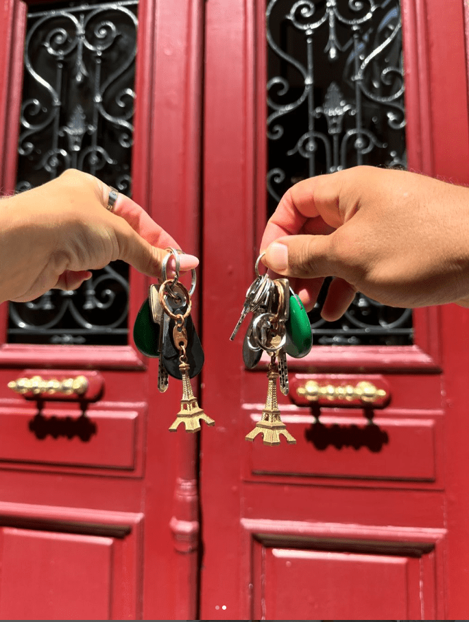 a person holding a bunch of keys in front of a red door