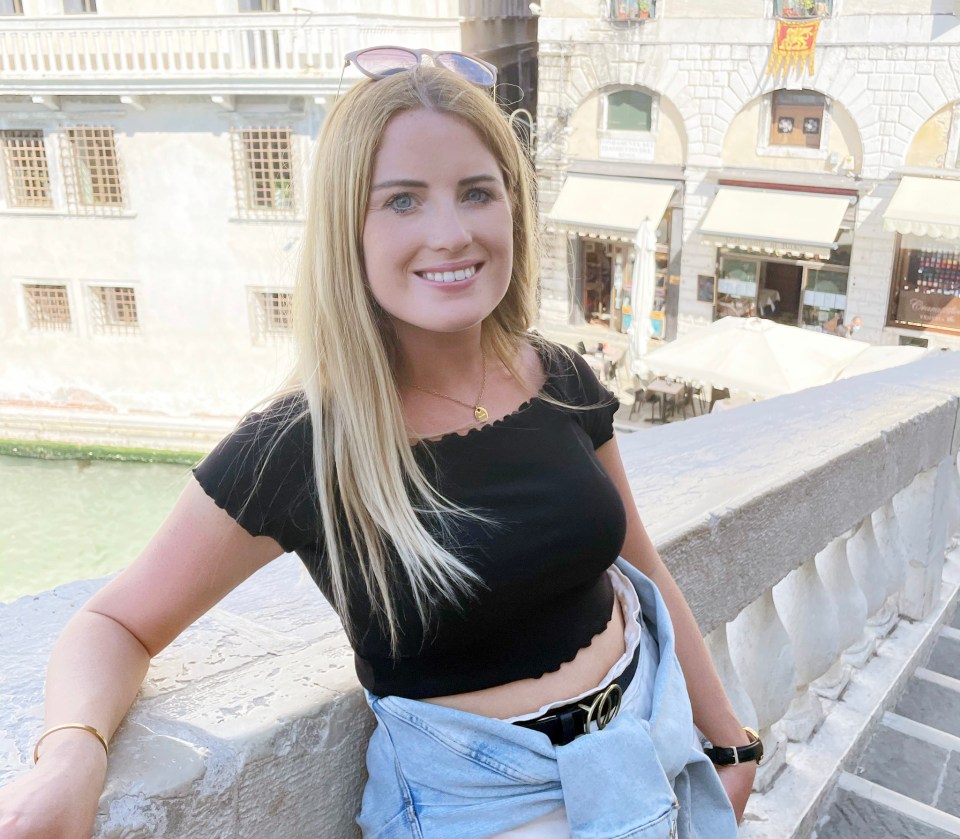 a woman in a black top leans on a railing