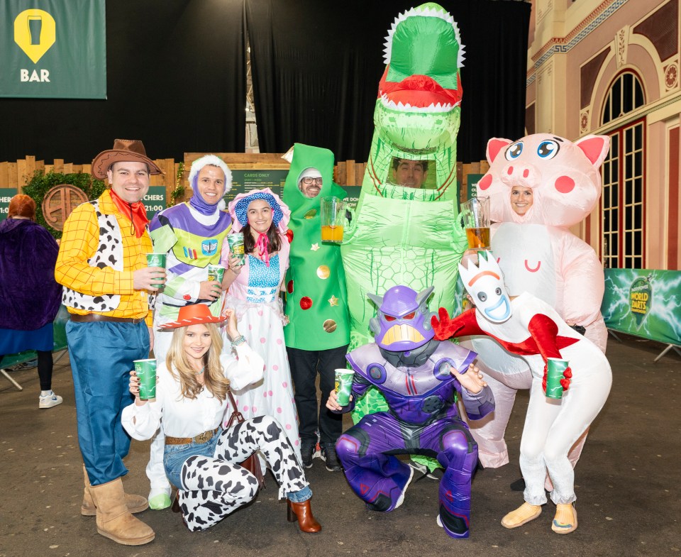 Group of people in Toy Story costumes at a darts event.