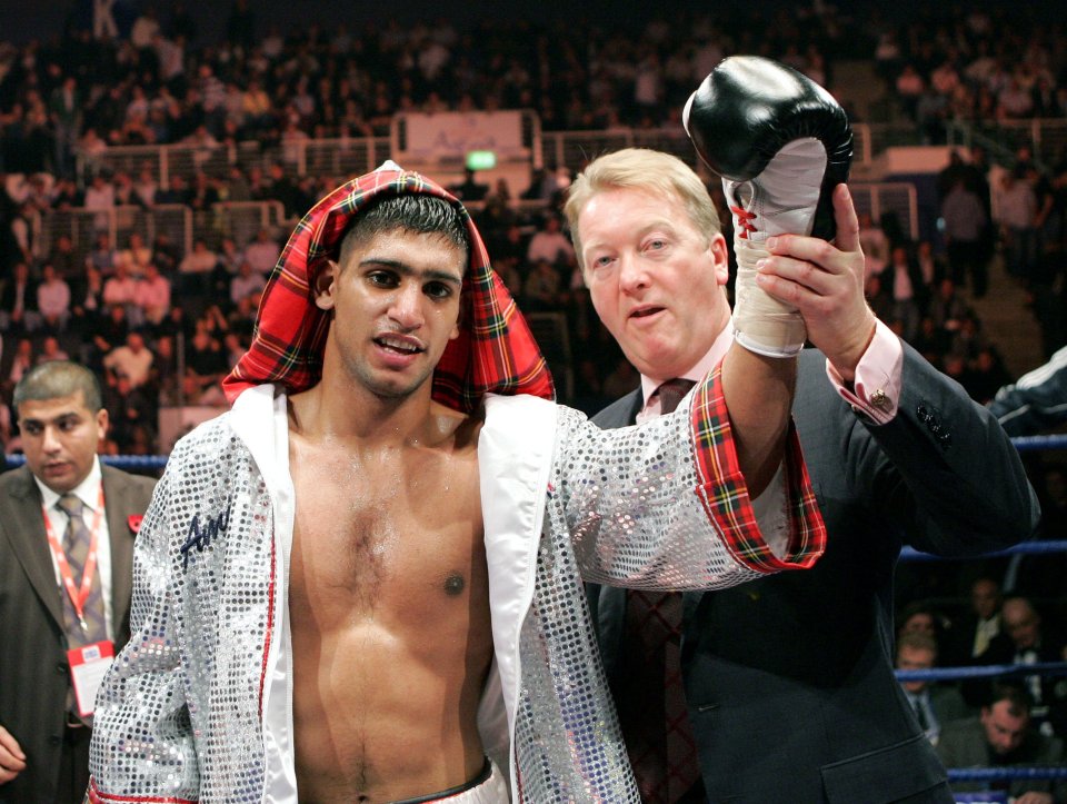 Amir Khan holding up a boxing glove with Frank Warren.