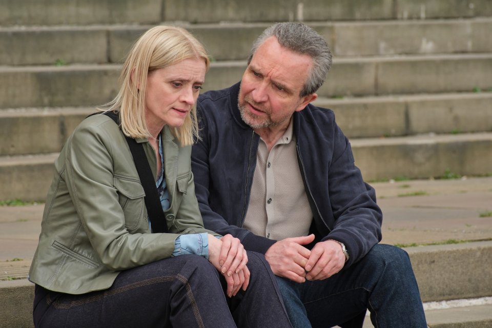 A man and woman sitting on steps, in conversation.