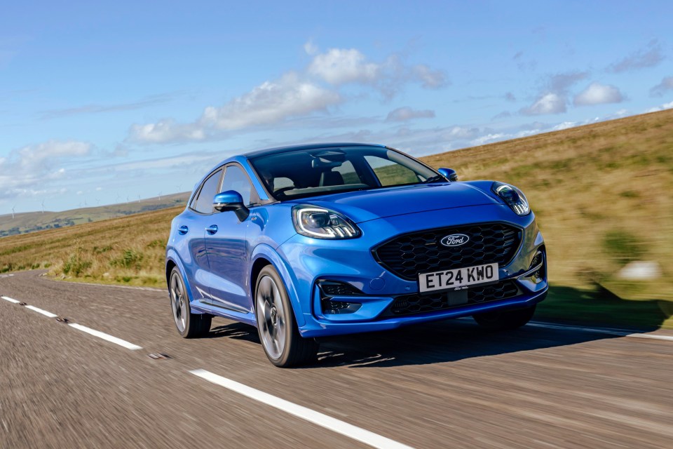 Blue Ford Puma driving on a road.