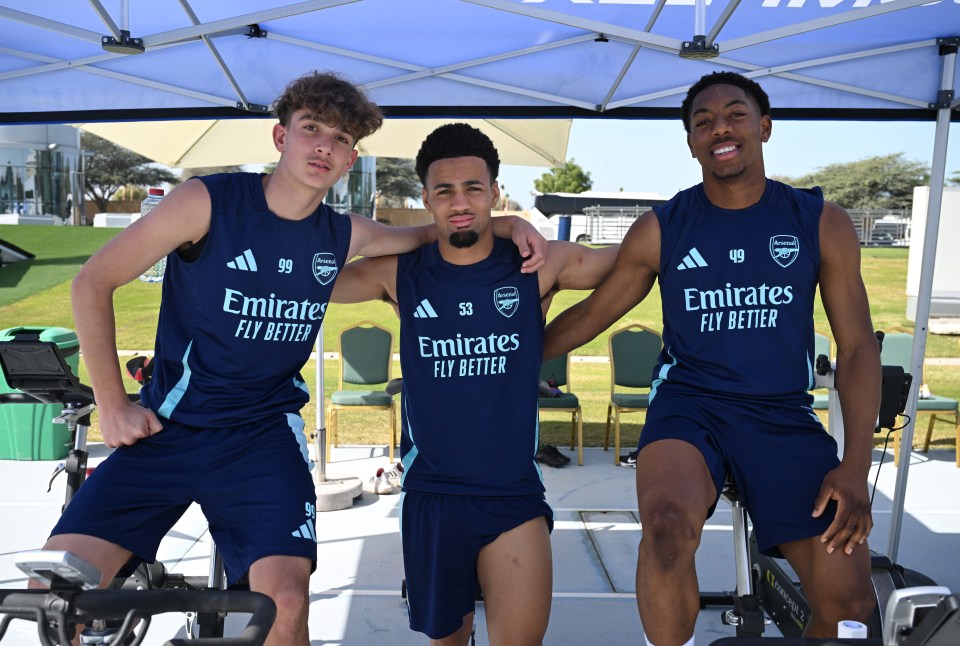 Three Arsenal athletes on stationary bikes during training.