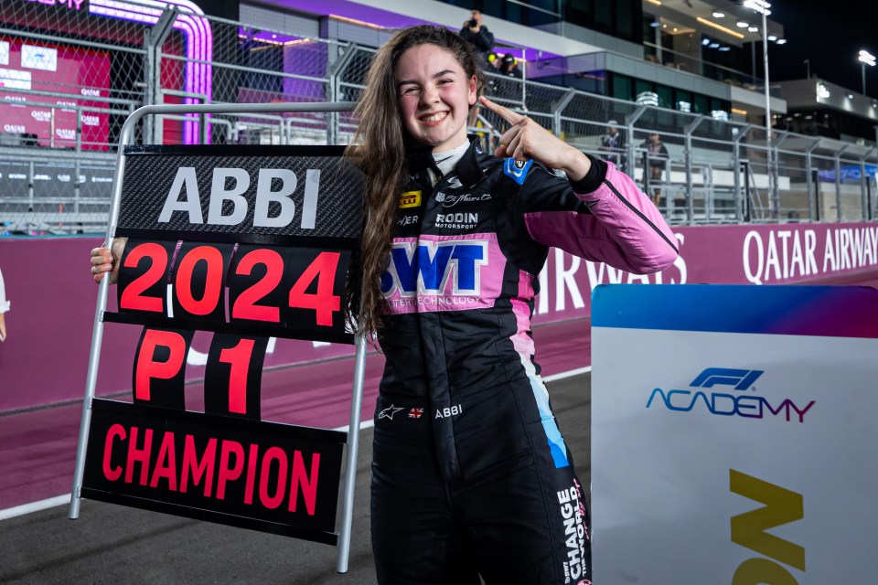 Abbi, 2024 F1 Academy champion, holding a scoreboard.