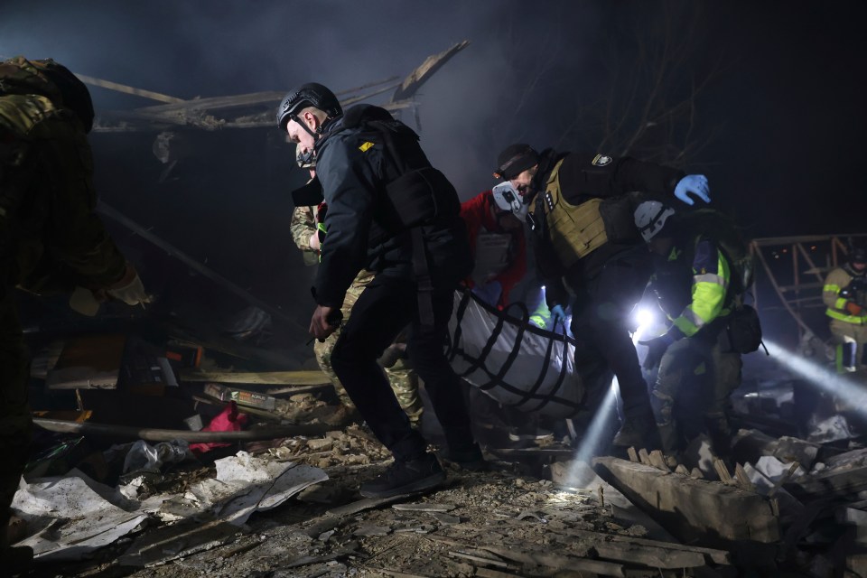 Police officers carry the body of a person killed by a Russian drone strike in a residential neighborhood in Zaporizhzhia, Ukraine, Friday, March 21, 2024. (AP Photo/Kateryna Klochko)