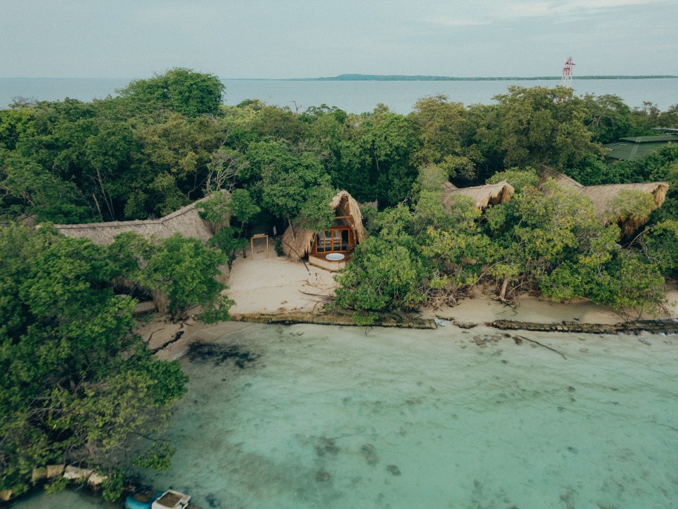 Aerial view of thatched-roof bungalows on Corona Island.