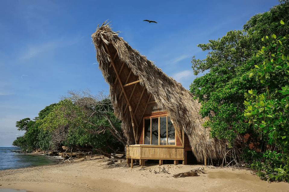Thatched-roof bungalow on Corona Island beach.
