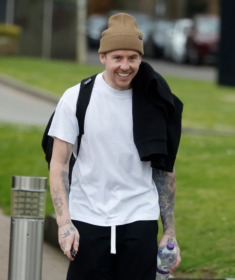 Danny Jones smiling while walking outdoors.
