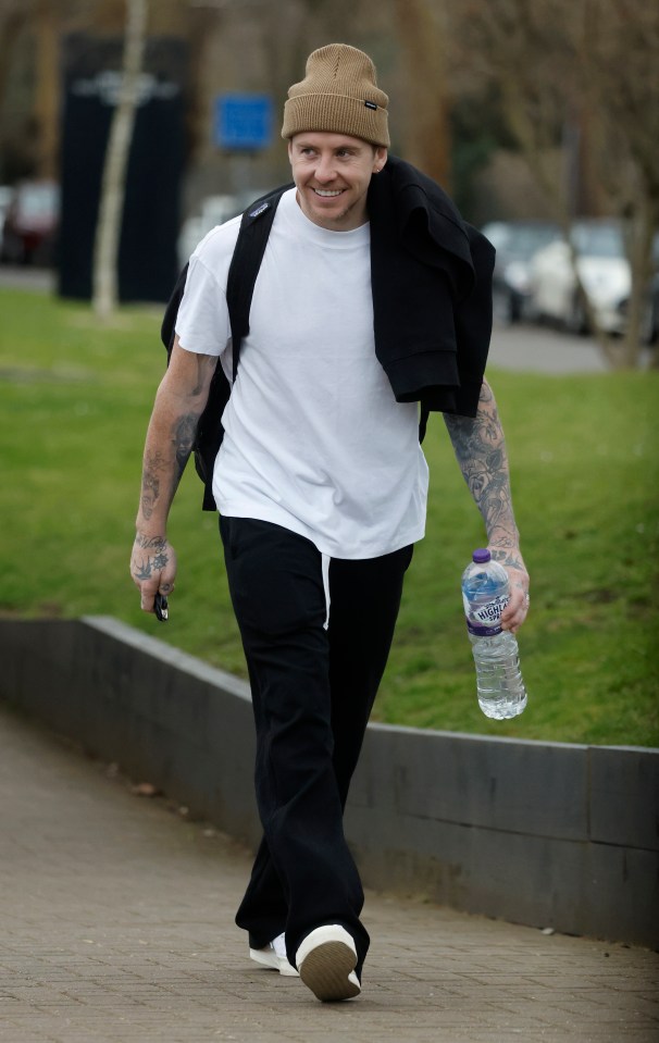 Danny Jones walking down a sidewalk, smiling.