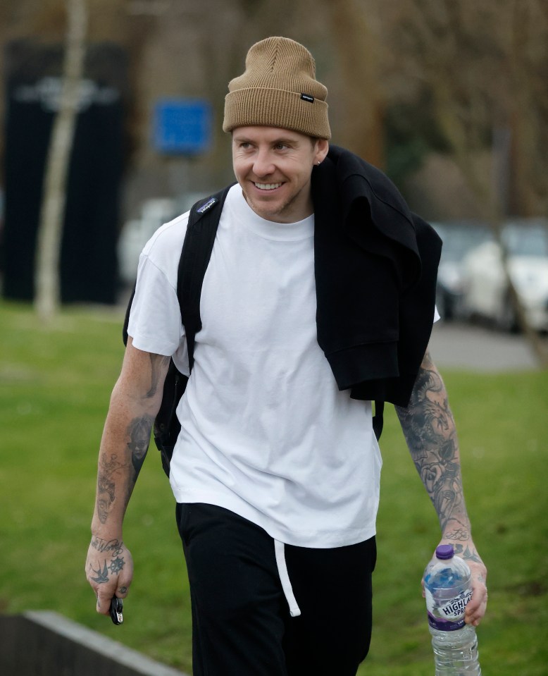 Danny Jones walking and smiling in West London.
