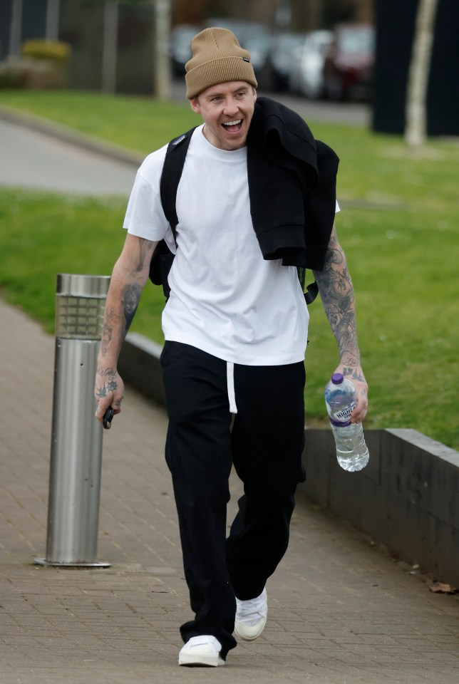 Danny Jones smiling while walking down the street.