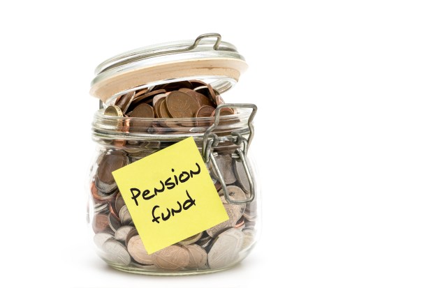 Glass jar full of coins with a yellow sticky note reading "Pension fund".