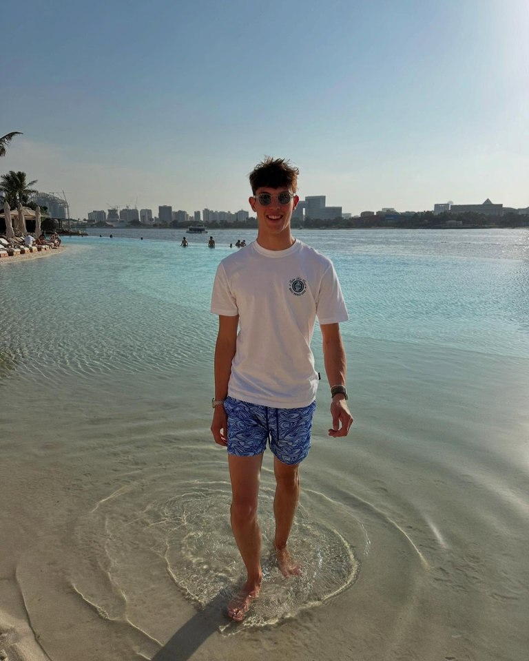 Man in swim trunks wading in shallow water.