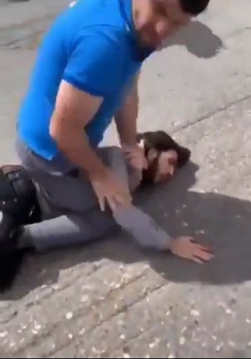 Person being restrained on the ground.