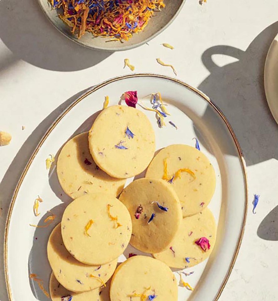 Shortbread cookies with edible flowers on a plate.
