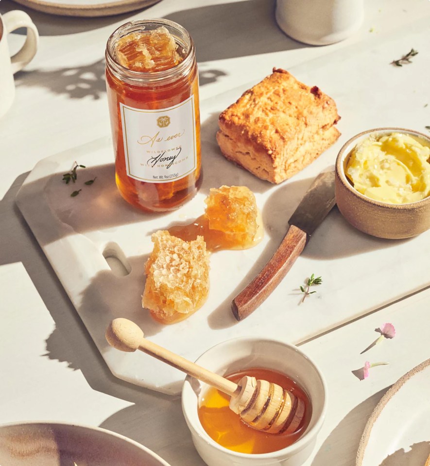 Honeycomb and honey jar with scone and butter.